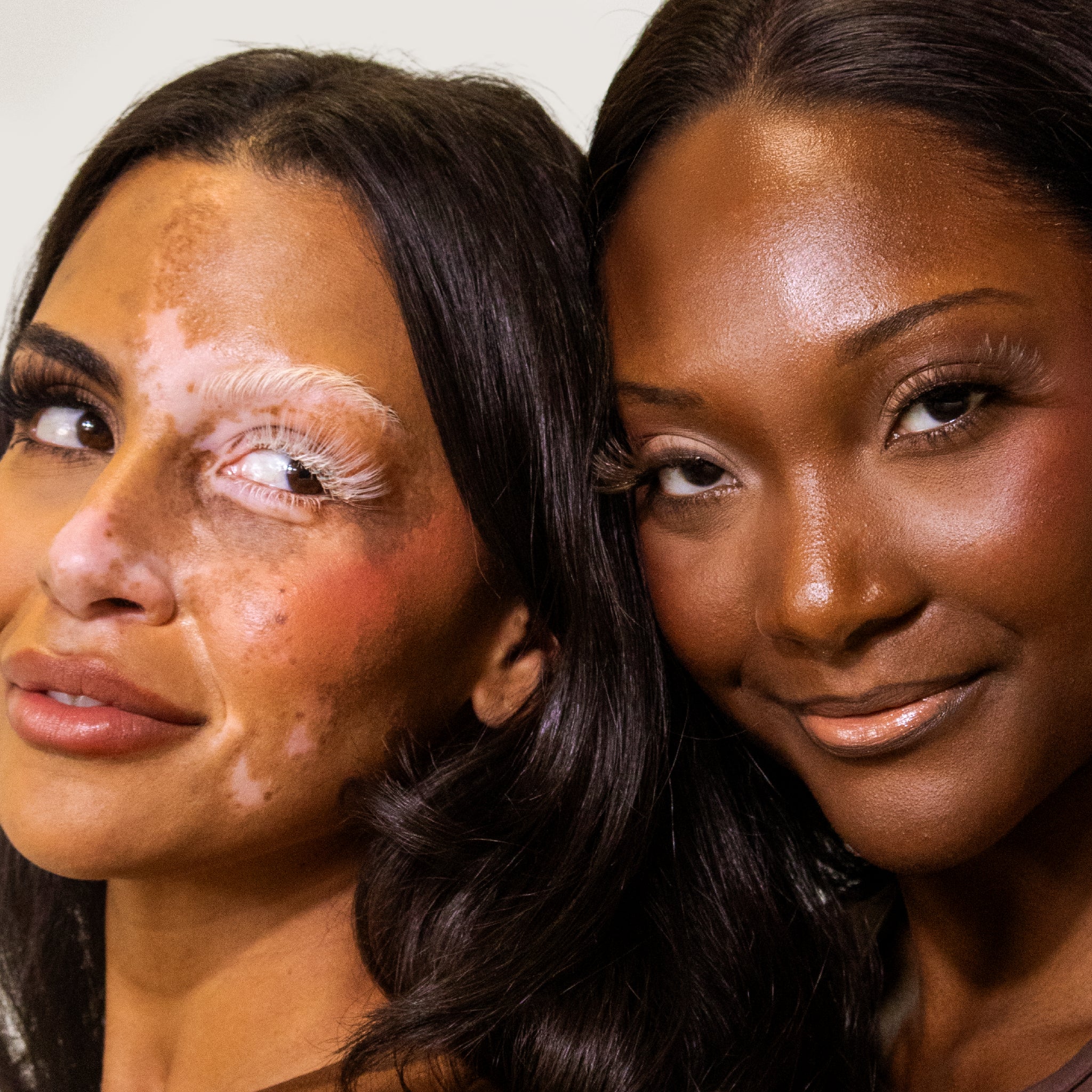 Two models with different skin tones wearing Bahira lashes